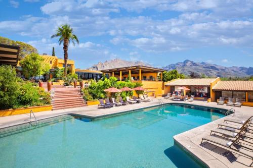 土桑韦斯特瓦尔德温德姆度假酒店&Spa的一个带椅子和棕榈树的度假村游泳池