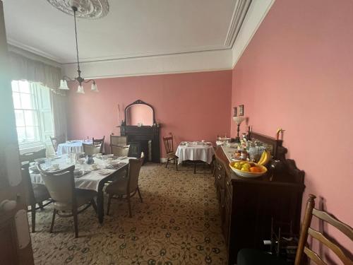 卡舍尔Ashmore House的用餐室设有粉红色的墙壁和桌椅