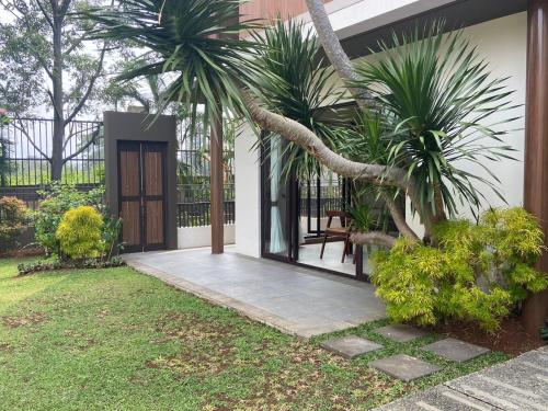 Gadok 1Private Villa 3+1BR in Vimala Hills的一座房子,设有种有棕榈树的庭院和一扇门