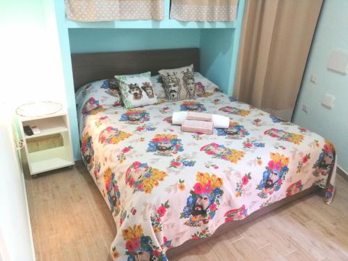 贾迪尼-纳克索斯I mori di Sicilia的一间卧室配有一张带花卉床罩的床