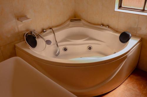 基加利SUNFLOWER HOMEs VILLA的浴室角落的浴缸