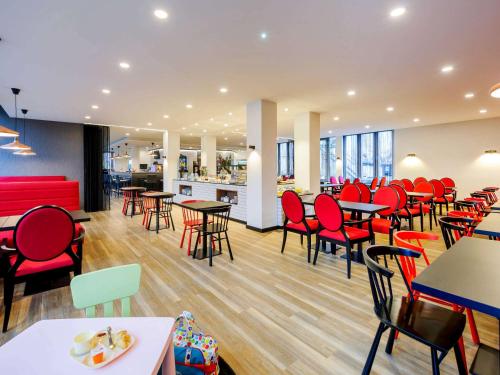 萨勒河畔哈雷哈雷宜必思尚品酒店的一间设有红色桌椅的餐厅和一间自助餐厅