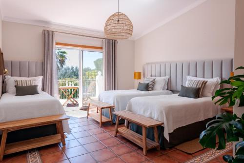 拉戈斯Quinta Bonita Country House & Gardens的一间带两张床的卧室和一个阳台