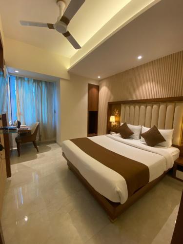 纳威孟买Hotel Czar Inn - Vashi Navi Mumbai的一间卧室配有一张大床和一张书桌