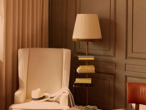 波尔多Mondrian Bordeaux Les Carmes的一间设有椅子和一盏带帽子的灯的房间