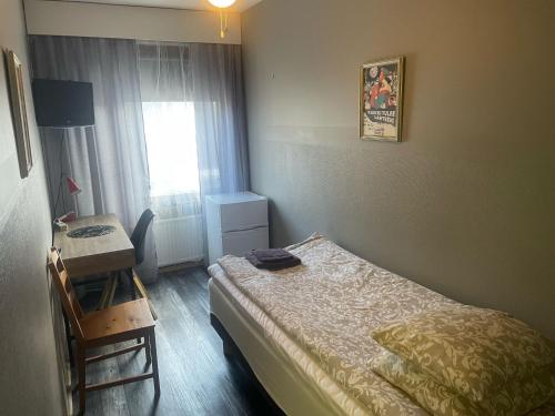 拉赫蒂玛卡考提帕特里亚旅馆的一间卧室配有一张床、一张书桌和一个窗户。