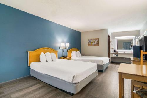 布兰森Econo Lodge的酒店客房设有两张床和蓝色的墙壁。