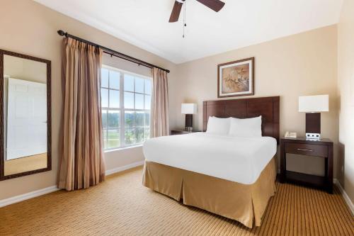 奥兰多Hilton Vacation Club Aqua Sol Orlando West的一间卧室设有一张大床和一个大窗户