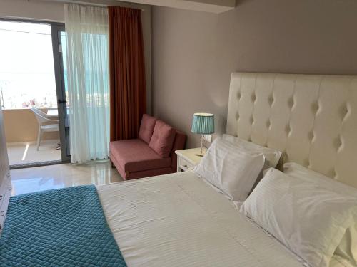 阿齐欧斯·贡多斯Agios Gordios Boutique Resort的卧室配有床、椅子和窗户。
