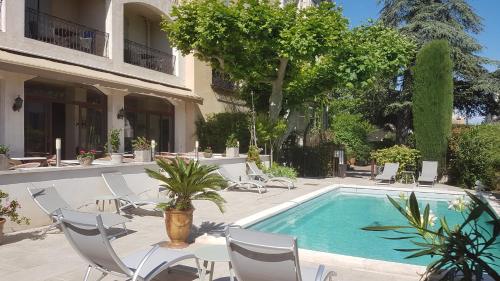 圣雷米普罗旺斯科斯特艾尔皮酒店的一座带桌椅的游泳池以及一座建筑