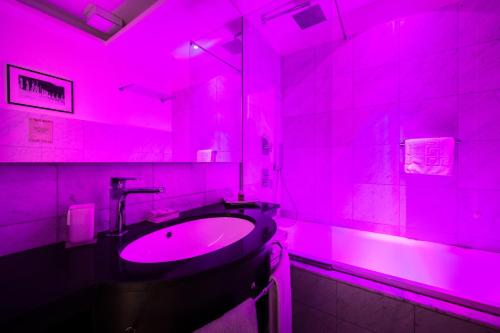 罗马玛切里诺套房旅馆的粉红色的浴室设有水槽和镜子