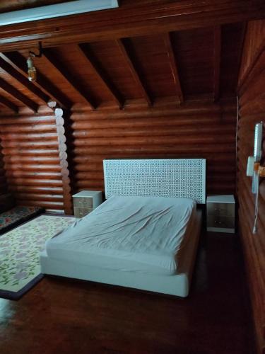 PiroğluChalet's lake_Bolu Abant _log house的卧室配有一张白色的木墙床
