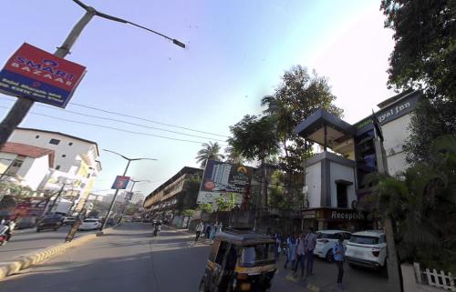 门格洛尔Hotel Royal Inn Mangalore - Opp SDM Law College MG Road的一条繁忙的城市街道,路边有汽车和人