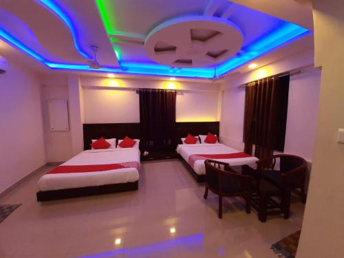 门格洛尔Hotel Royal Inn Mangalore - Opp SDM Law College MG Road的一间卧室设有两张床和蓝色灯光天花板。