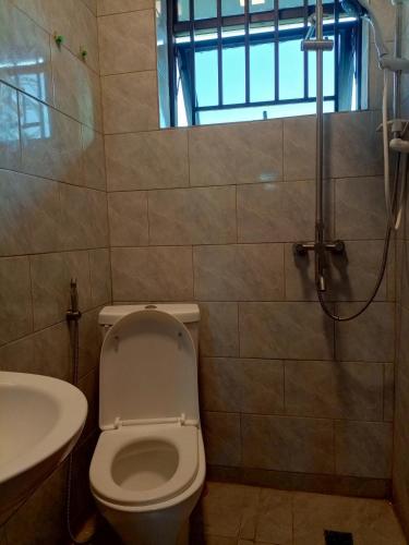 基加利Kigali Grand Villa的浴室配有卫生间、盥洗盆和淋浴。