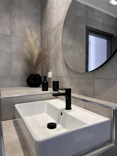 阿彻奇洛斯斯特纳大海阳光旅馆的浴室设有白色水槽和镜子