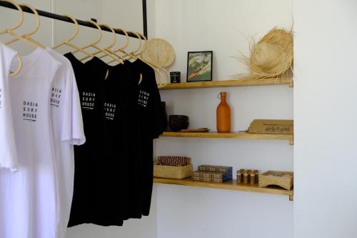 韦利格默OASIA - Boutique Surf House (ADULTS ONLY)的衣柜,带黑色连衣裙和架子