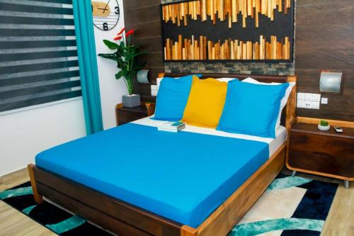 科托努l'Eldorado的一间卧室配有蓝色和黄色枕头的床