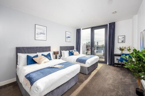 伦敦Luxury & Spacious 2 BR APT with City Views的一间卧室设有两张床和大窗户
