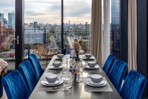 伦敦Luxury & Spacious 2 BR APT with City Views的一张带蓝色椅子的桌子,享有城市美景