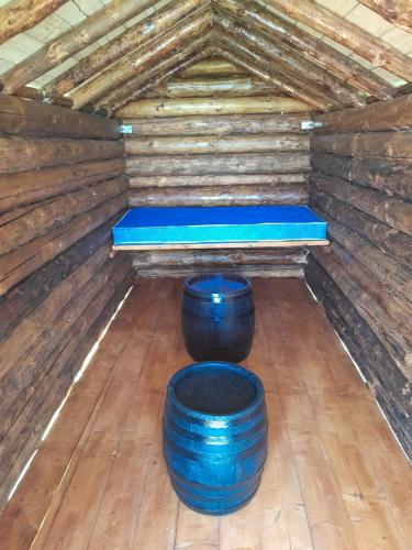 MiročBungalov的一间有两桶蓝色桶和一个床垫的房间