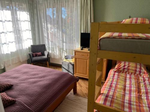 萨拉茨格里瓦Family house room的一间卧室配有两张双层床和椅子
