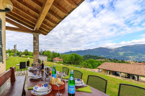 卡斯泰尔韦卡纳Oasi di Castelveccana Apt Pool and View的美景庭院里摆放着带食品和饮料的桌子