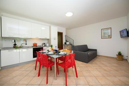 拉韦诺-蒙贝洛Le Betulle Garden in Laveno的厨房以及带红色椅子和桌子的客厅。