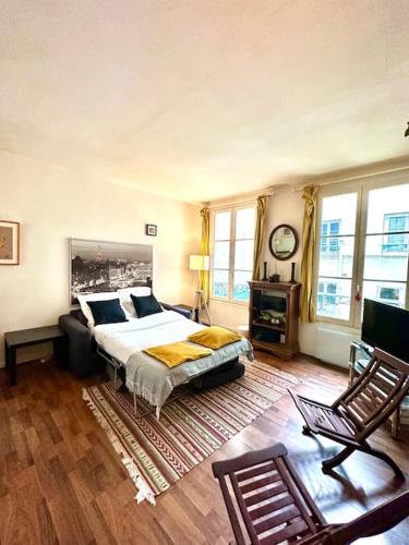 巴黎Cozy 1BR in the Heart Of Paris的卧室配有床、桌子和窗户。