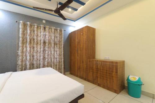 戈勒克布尔SHREE Ram hotel的一间卧室配有一张床和一个木制橱柜