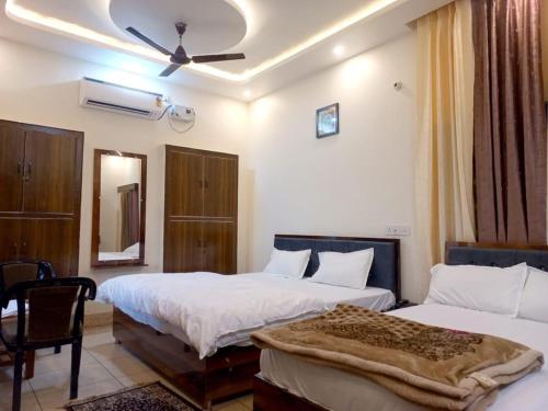 AyodhyaKalash Guest House的酒店客房,配有两张床和椅子