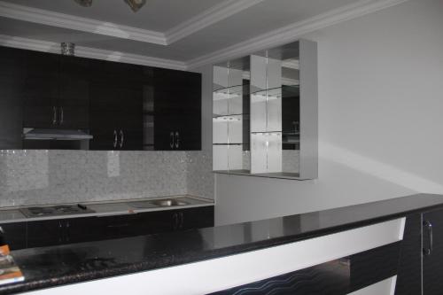 PanjakentHostel Asham的厨房配有黑色橱柜和白色台面