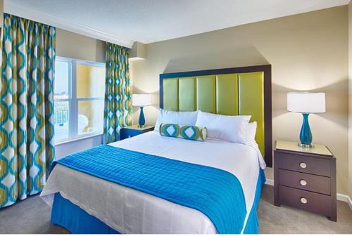 奥兰多Be Our Silver Guest的一间卧室配有一张大床,设有蓝色和绿色的床头板