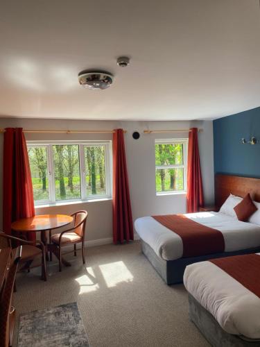 科克Fernhill Lodge Carrigaline的酒店客房设有两张床和一张桌子。