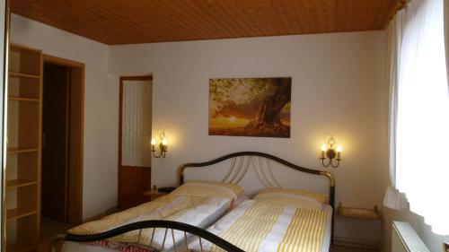 卡劳特格瑞斯赫Ferienwohnung Frenzel的卧室配有一张床,墙上挂有绘画作品