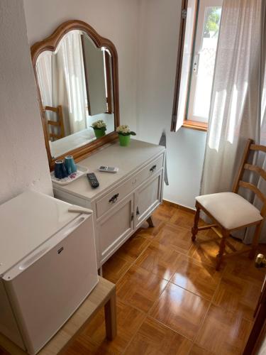 拉戈斯Pensão Dona Ana - Residencial的浴室设有梳妆台、镜子和椅子