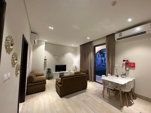 塞拉莱Wonderful Ground Studio - Hawana Salalah Resort的客厅配有白色桌子、沙发和电视
