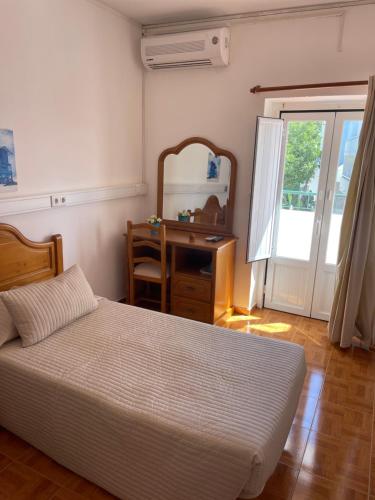 拉戈斯Pensão Dona Ana - Residencial的一间卧室配有一张床、一张书桌和一面镜子