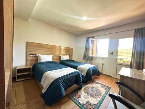 艾兹鲁AUBERGE JOMANA PARK的酒店客房设有两张床和窗户。