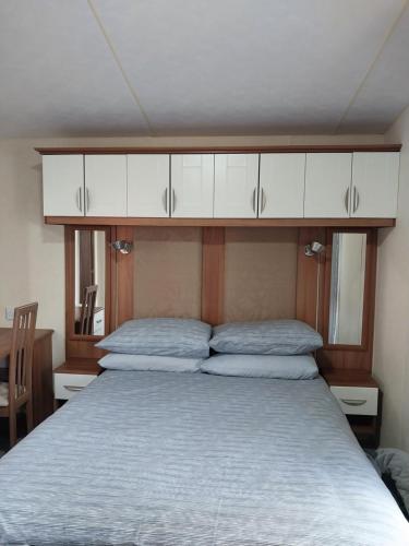 PlumblandWoodside, Meadows Retreat, Cockermouth的卧室内一张上方白色橱柜的床