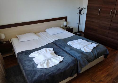 班斯科Family 2 bed Apartment in Bansko的一间卧室配有一张带两条白色毛巾的床