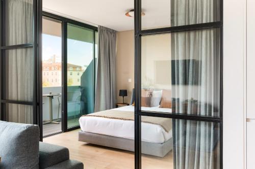 里斯本Mirabilis Apartments - LX Living的酒店客房设有一张床和一个阳台。