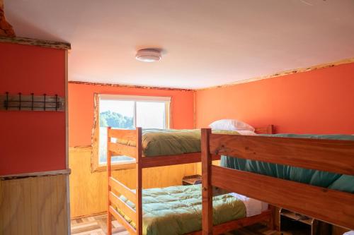 库拉考廷Cabañas & Hostal Lefuco的客房设有三张双层床和一扇窗户。