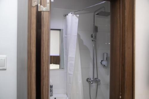 拉各斯Baseville Hotel的一间带白色淋浴帘的浴室