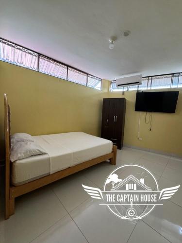 普卡尔帕The Captain House的一间卧室配有一张床,并在一间客房内配有电视。