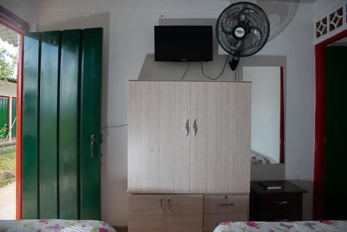 亚美尼亚La Mía Hospedaje的一间卧室设有1个带电视和风扇的橱柜。