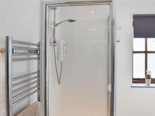Llangwm-isafTy Ffair Mai Annexe的浴室内装有玻璃淋浴间和电话的门