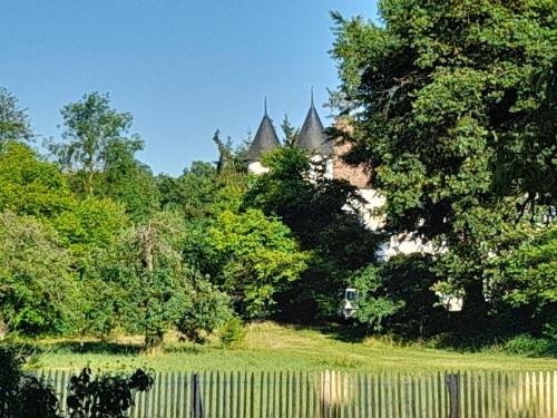 马泽内姆Les Cottages du Chateau de Werde的一座带围栏和树木的花园以及一座建筑