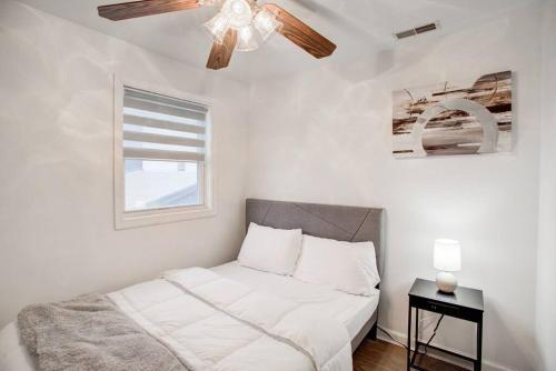费城Cozy Lux 3bd House Heart of Fishtown Sleeps 8的一间卧室配有一张带吊扇的床