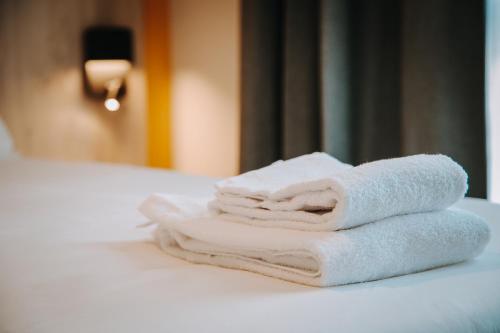 布鲁瓦Beelodge Hotel Blois Centre的床上的一大堆毛巾
